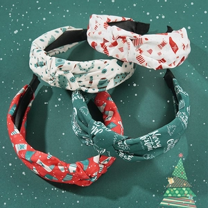 Set of four festive knotted Christmas headbands with holiday prints on snowy background