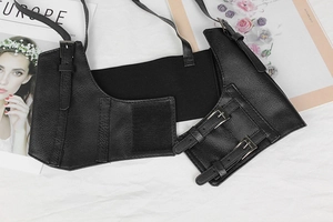 Detail of adjustable black faux leather corset belt with silver buckles and velcro closure