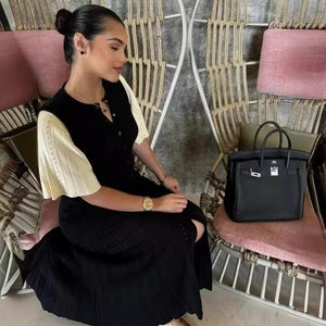 Elegantes kurzärmeliges Strickkleid mit schwarz-weißem Kontrast und Knopfdetails