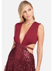 Détail d'une robe bordeaux à col en V profond avec découpes latérales et paillettes