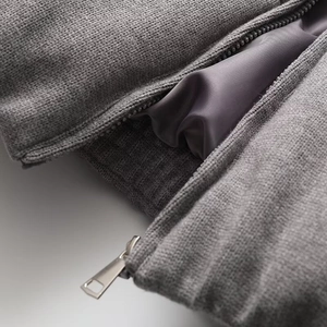 Macro detail of high-quality metal zipper and smooth inner lining on gray knitted jacket