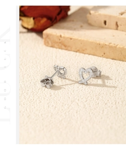 Detail of silver heart stud earrings with pave-set shimmering stones in natural light