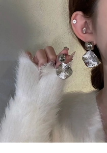 Vue détaillée de boucles d'oreilles carrées argentées avec texture martelée