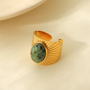 Close-up of vintage gold ring featuring a green turquoise stone and sunburst engraving