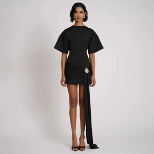 Detail of black mini dress featuring a round neck, golden buckle, and elegant waist streamers