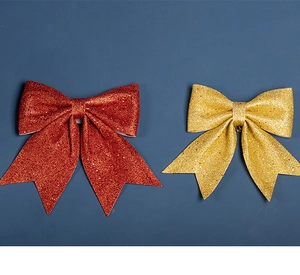 Gros plan de nœuds de Noël à paillettes rouges et dorées avec texture de coton perlé