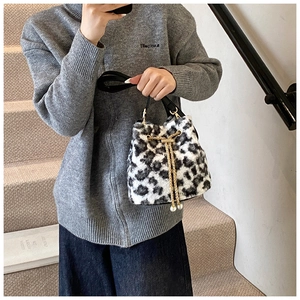 Detail view of leopard print plush bucket bag with golden chain and pearl accents