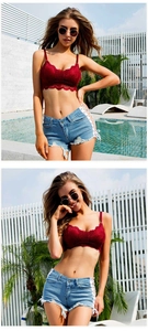 Dettaglio del crop top in pizzo rosso e pantaloncini di jeans blu con lacci laterali