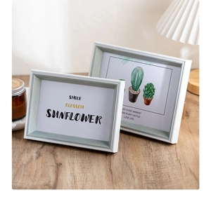 Detail of light green wood grain resin frames with Nordic sunflower and cactus art prints