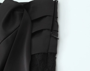 Detail of high-quality invisible zipper and floral lace stitching on black mini dress