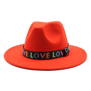 Détail du chapeau en laine orange avec ruban noir et broderie LOVE multicolore