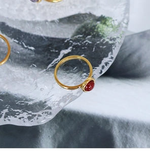 Detail of 18K gold-plated titanium ring with round red agate and vintage beaded edge