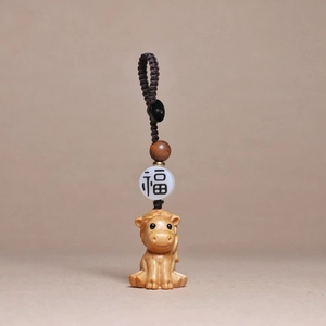 Detail of hand-carved wooden zodiac horse keychain with Fu bead and woven brown cord