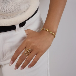 Close-up of gold starfish bracelet with colored stones and a matching four-diamond ring