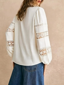 Back view of elegant white long-sleeve blouse with lace hollow stitching and bohemian cut