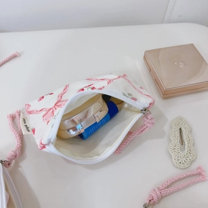 Detail of pink floral cotton pouch with braided handle and simple wish label