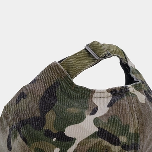 Close-up of camouflage baseball cap with metal buckle strap and twill canvas texture
