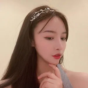 Elegant headband with star motifs and pearls on thin metal frame worn by a model