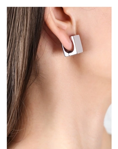 Close-up of polished silver geometric rectangular earrings on model with high gloss finish