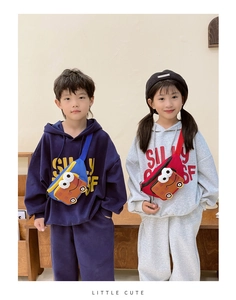 Detail of blue and red cartoon car waist bags with adjustable straps on child models