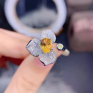 Macro shot of luxury clover flower ring with yellow gemstone and micro-pave diamonds