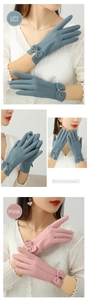 Detail of winter warm gloves with elegant bow cuff and touchscreen embroidery on index finger