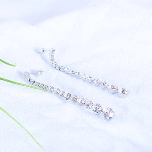 Macro view of long silver tassel earrings with sparkling white cubic zirconia stones