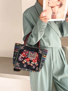Ethnic embroidered tote bag featuring colorful elephant patterns and woven handles