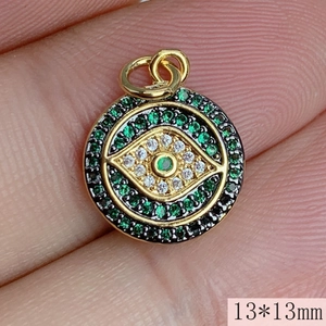 Macro shot of 13mm gold devil eye pendant with green and white zircon inlay detail