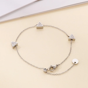 Detail of silver chain bracelet with three triangle charms pavé-set with cubic zirconia