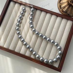 Detailed macro view of large grey imitation pearls with silver metal lobster clasp