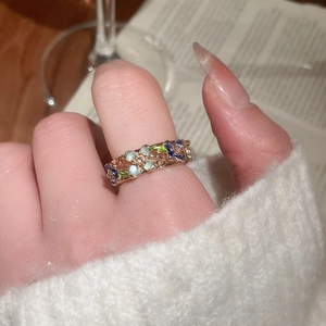 Detail of vintage gold-plated floral ring with colorful enamel flowers on model hand