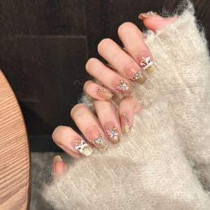 Close-up of handmade press-on nails with 3D lion head, butterfly, and golden glitter charms