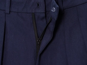 Detail of navy blue twill pants featuring a secure zipper fly and single button closure