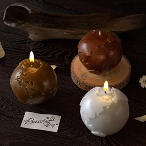 Detailed relief of world map on 3D earth sphere candles in earth-toned colors