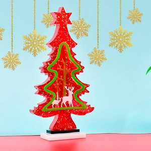 Sparkly red Christmas tree decor with green reindeer silhouette and white square base
