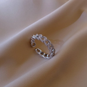 Detail of silver chain link ring with micro-pave cubic zirconia on silk background