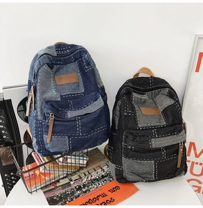 Detail of vintage patchwork denim backpack featuring leather zip pulls and stitching
