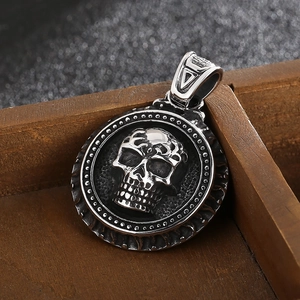 Close-up of a silver stainless steel skull pendant with an intricate circular frame