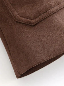 Detailed close-up of stitching and suede texture on brown trench coat pocket