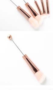 Close-up of DIY rose gold beadable makeup brushes with soft pink synthetic bristles