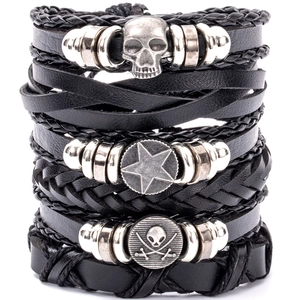 Detail of multi-layered black leather bracelets with skull, star, and pirate metal charms