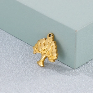 Macro shot of a golden tree-shaped pendant with a polished metallic finish on blue