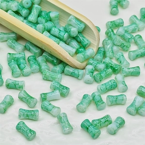 Vue détaillée de perles cylindriques motif marbre vert et blanc pour la création de bijoux DIY