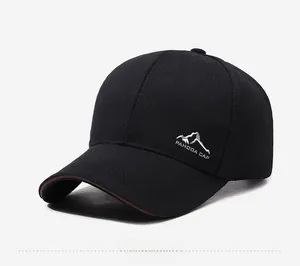 Dettaglio del cappellino nero in cotone con ricamo montagna e bordo marrone