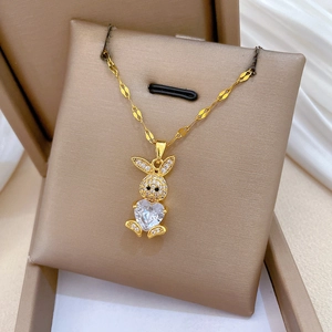 Dettaglio macro della collana a coniglio dorata con ciondolo a cuore in diamante