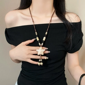Bohemian leather cord necklace with yellow star pendant and beaded tassels on black top