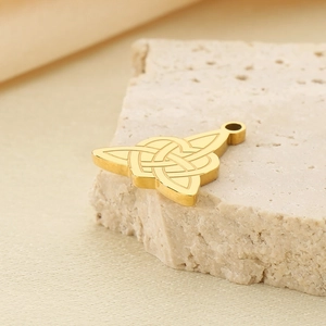 Pendentif noeud celtique en acier inoxydable doré sur un fond élégant en pierre beige