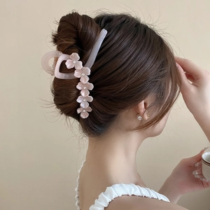Pince à cheveux fleur rose avec strass portée dans un chignon à la française