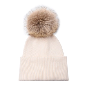 Close-up of beige ribbed knit baby beanie featuring a fluffy detachable brown faux fur pom